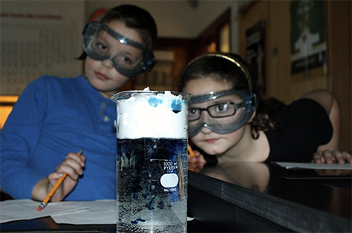 two students looking at liquid in a beaker