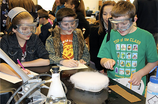 three students experimenting with dry ice