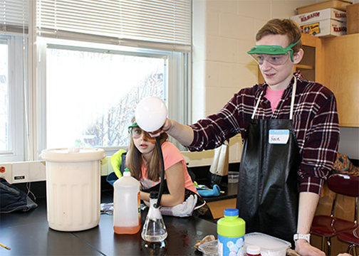 high school student performing an experiment with soap bubble filled with dry ice