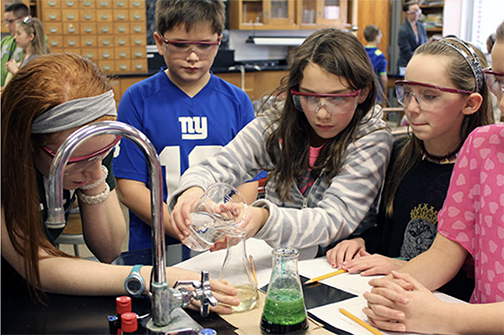 four students performing a science experiment