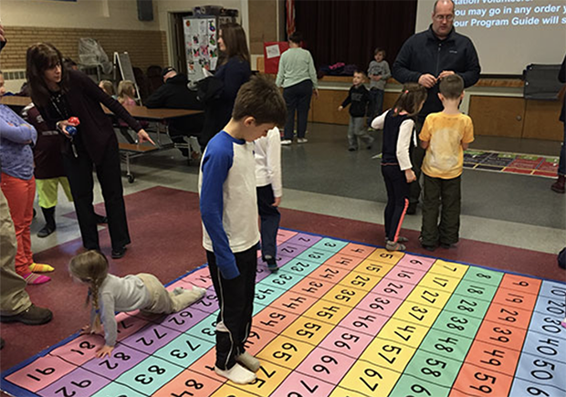 student walking on a colorful mat with numbers on it