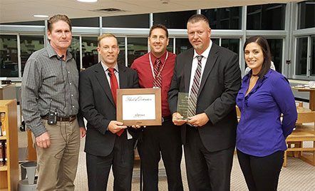 five adults holding plaque