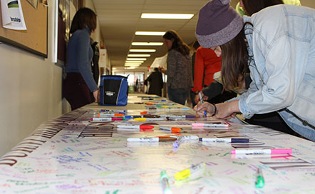 Students write on banner