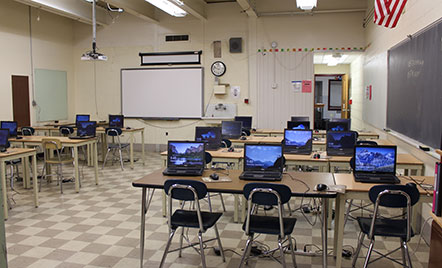 old computers on outdated tables in an old classroom