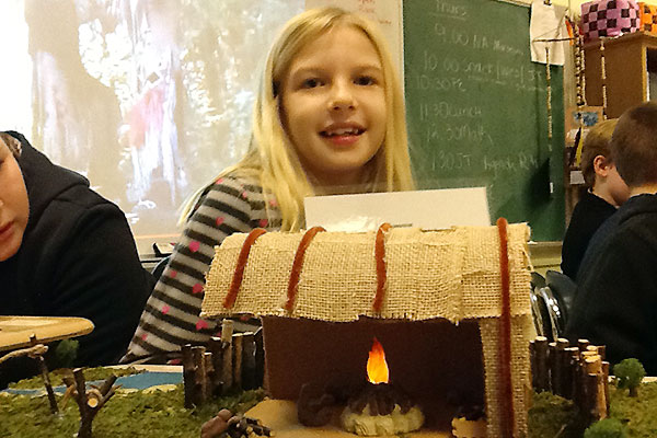 Girl showing Native American house diorama