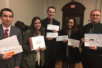 students lined up holding awards