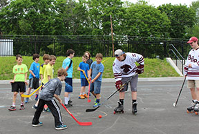 students on pavement playing hockey