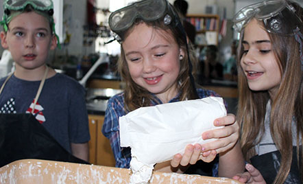 grade 4 student pouring ingredients into a tub