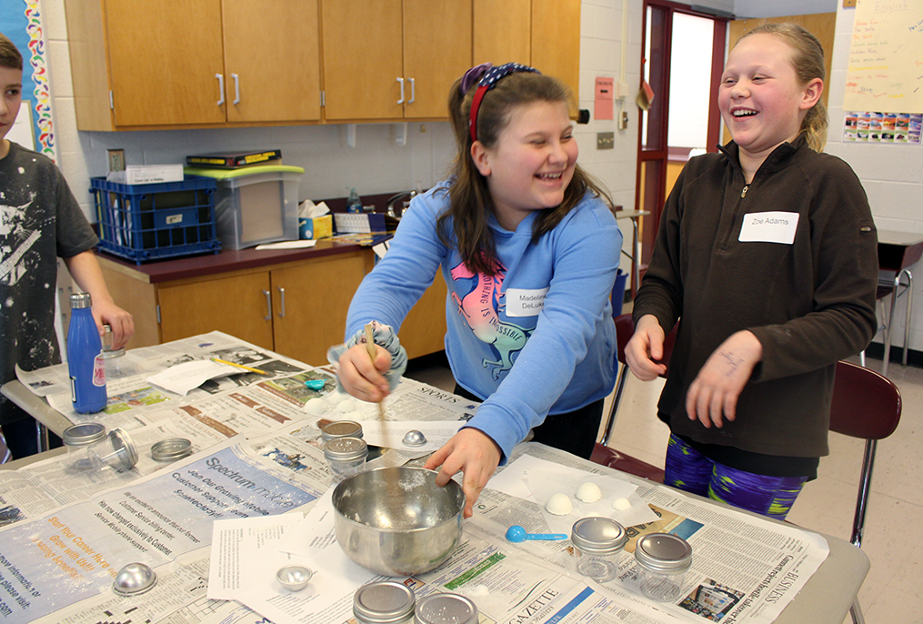 two students using mixing bowl to make bath bombs