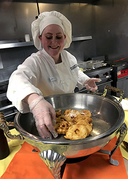 student wearing chef hat and smock 