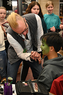 adult painting student's face green