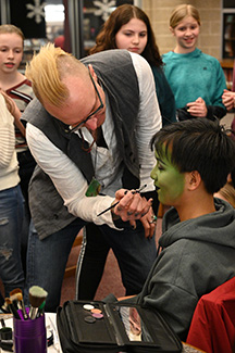 adult painting student's face green