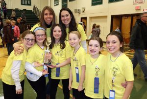 students and two adults wearing matching yellow shirts and wearing winning ribbons