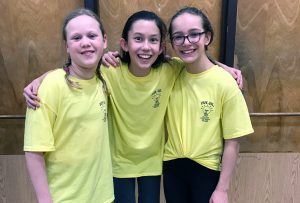 three students wearing matching yellow shirts