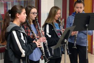 middle school students playing clarinets in hallway peformance