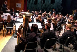 students playing instruments during concert on stage