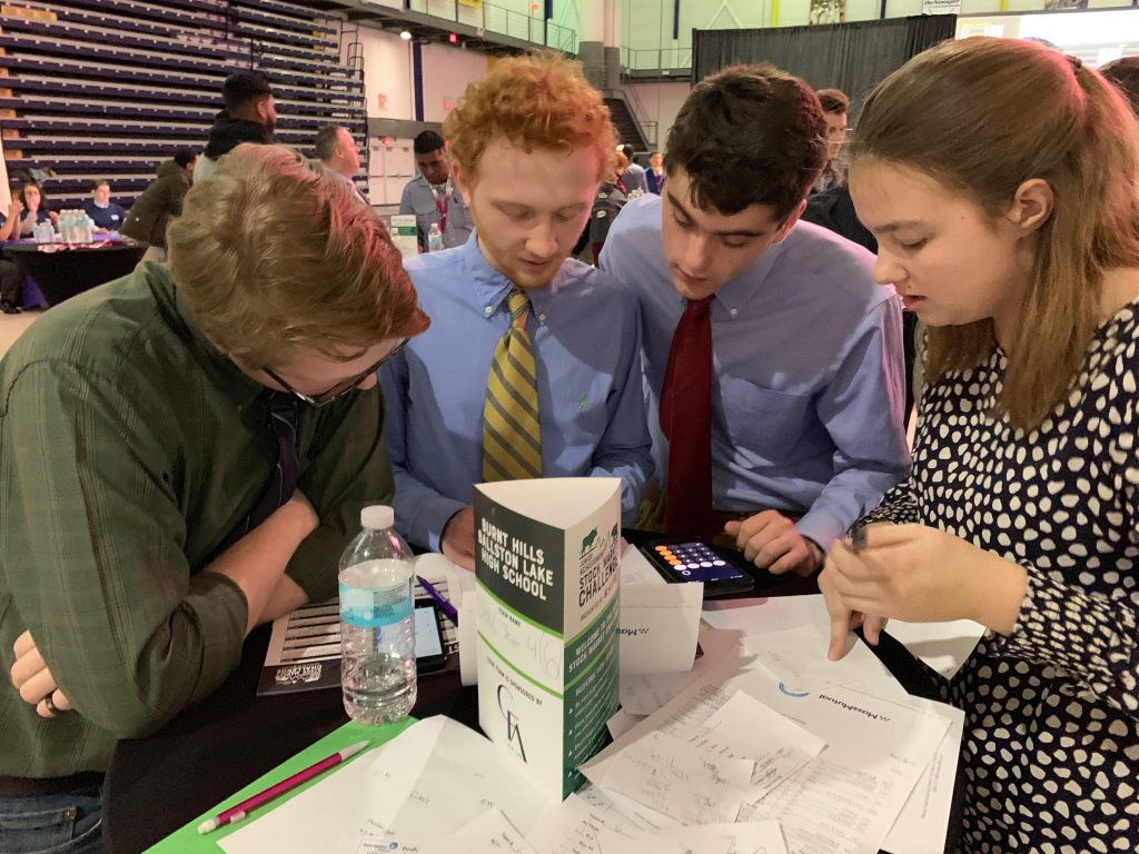 students looking down at a calculator