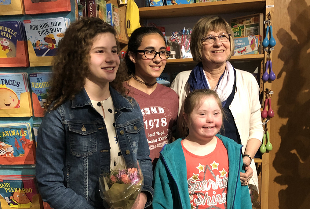 three students and one adult posing for photo