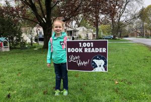student standing next to 1001 Book Reader sign