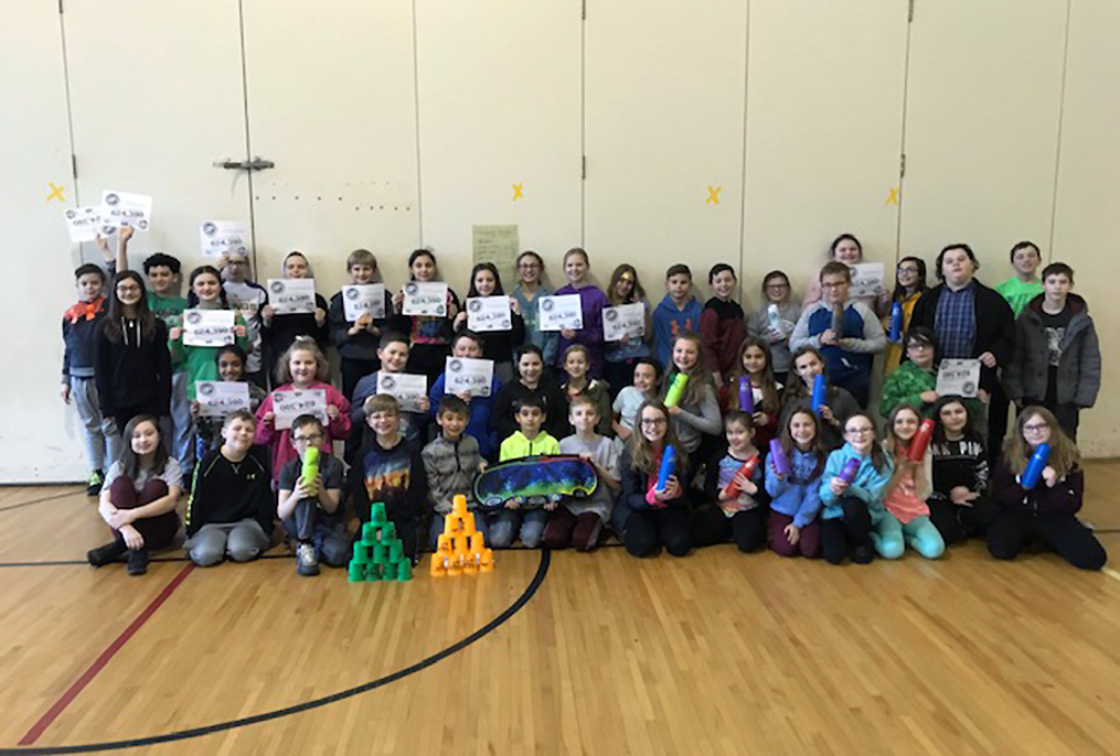 students holding paper certificates