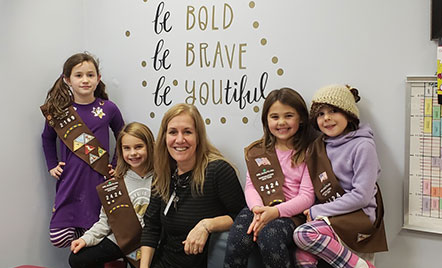 four students part of girl scouts with theacher