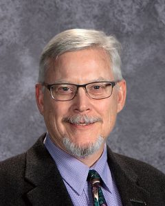 adult wearing purple shirt and suit jacket with tie