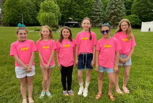 six students wearing bright pink shirts