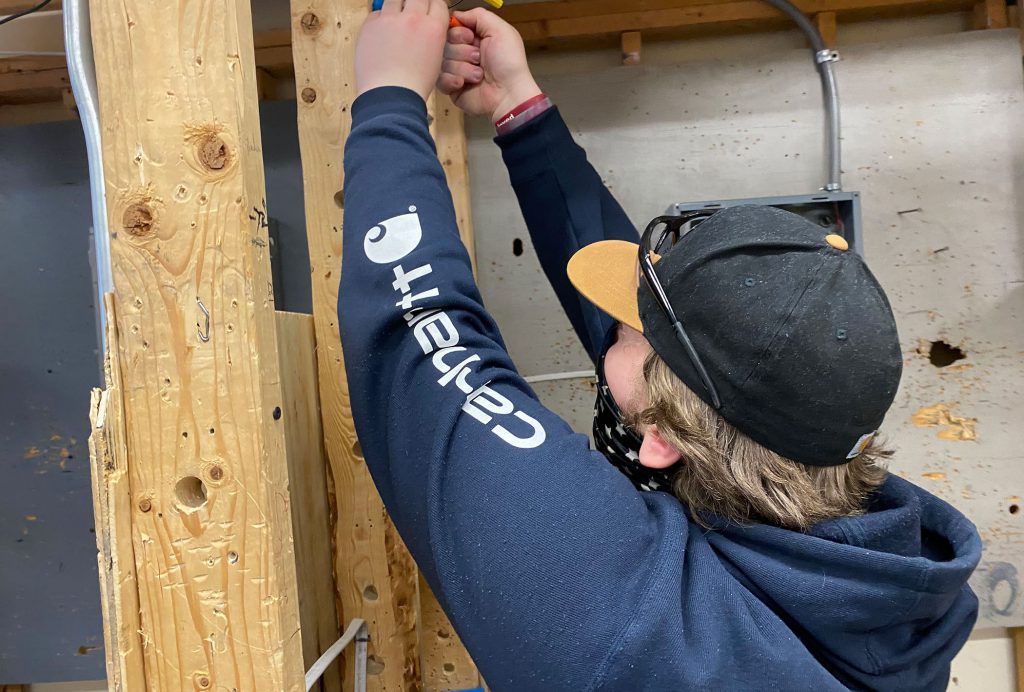 student working with wires against wood