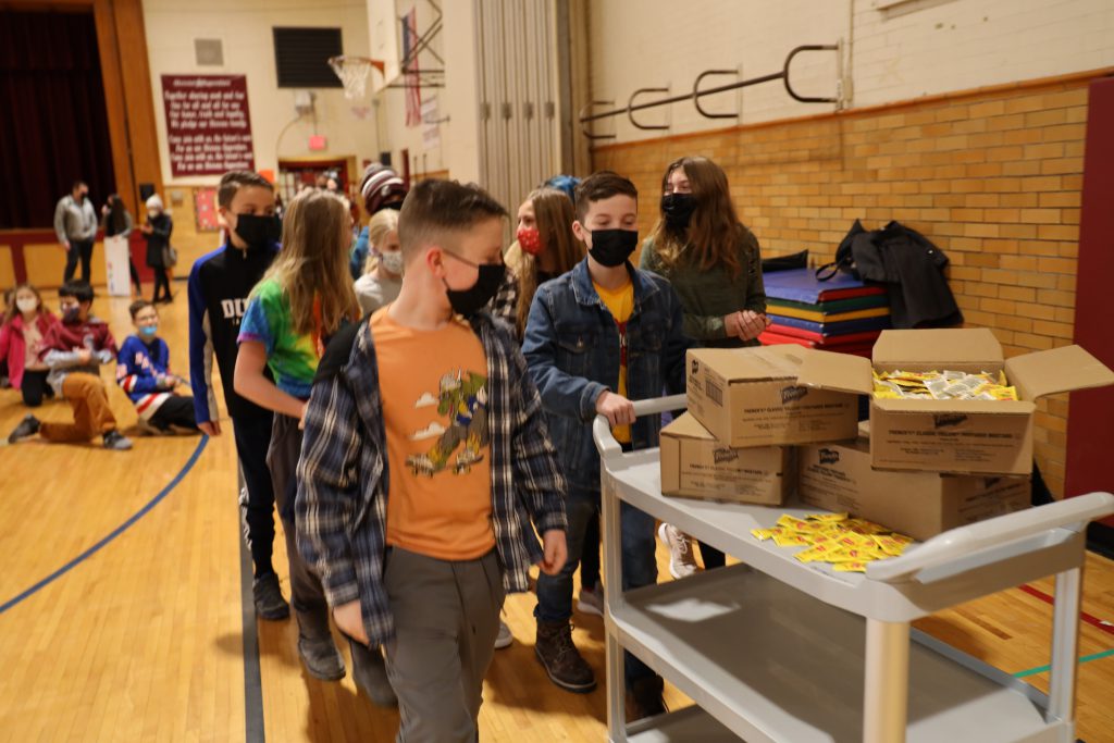 students pushing a cart with boxes on top