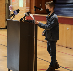 student at a podium talking into microphones