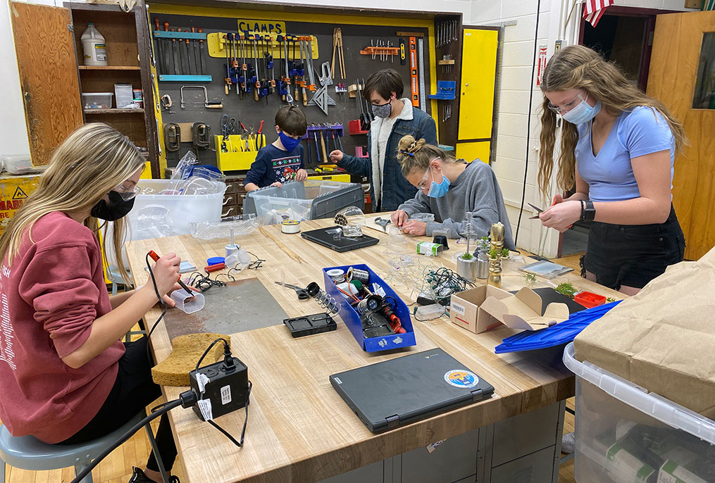 students using tools at a work bench