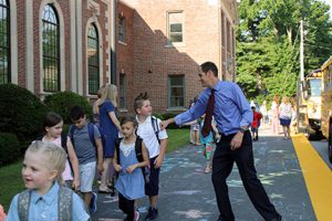 students walking on sidewalk into school