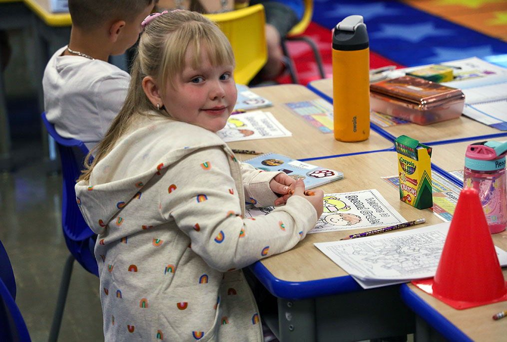 A student coloring a picture at school.