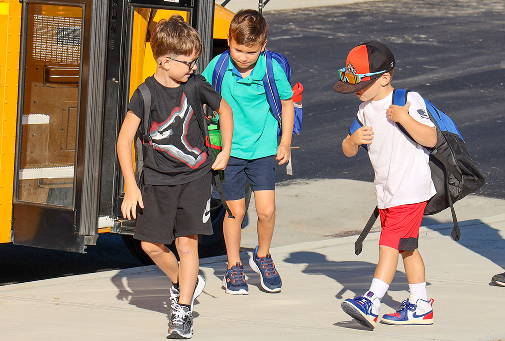 Students getting off the bus on the first day of school.