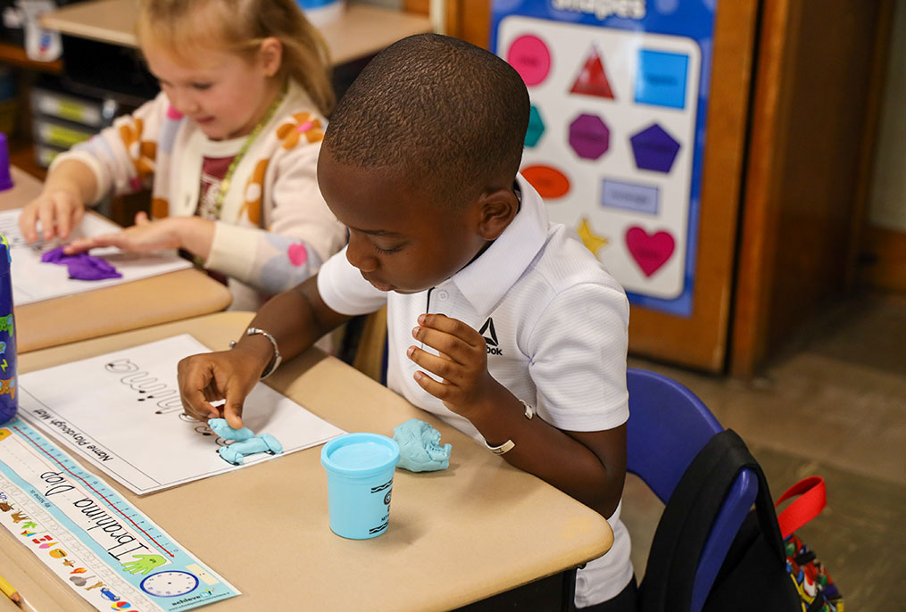 A student spelling their name with Play-Doh.