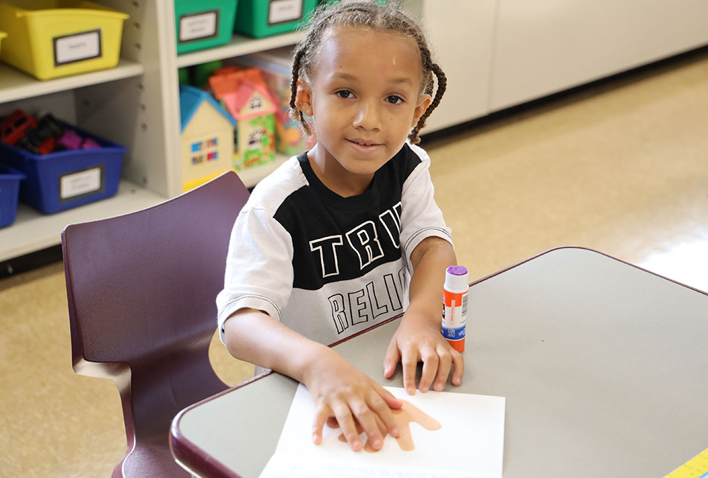 A kindergarten student working in a classroom.