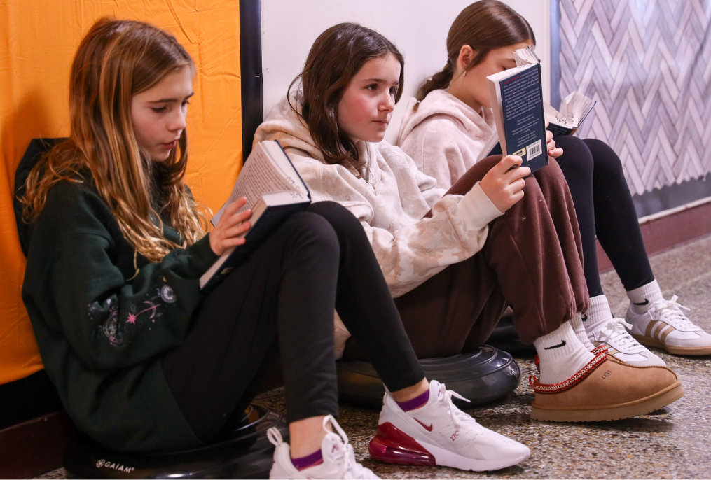 Students are reading in the hallway.