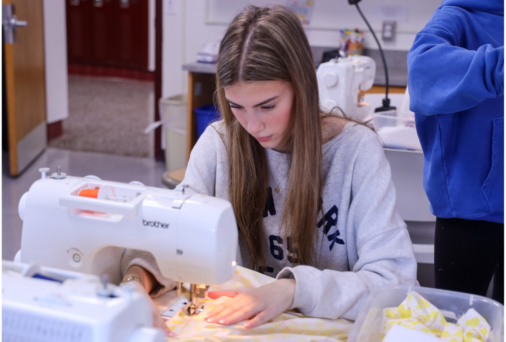 A student working with a sewing machine.