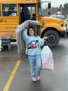 student carrying a bag of donationed items