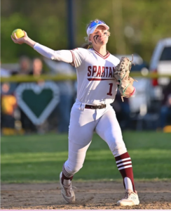 student in uniform throwing a softball