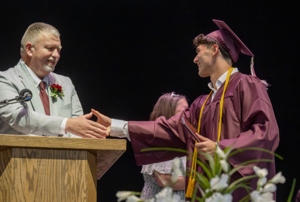 A BHBL graduate shaking hands with the principal at graduation.
