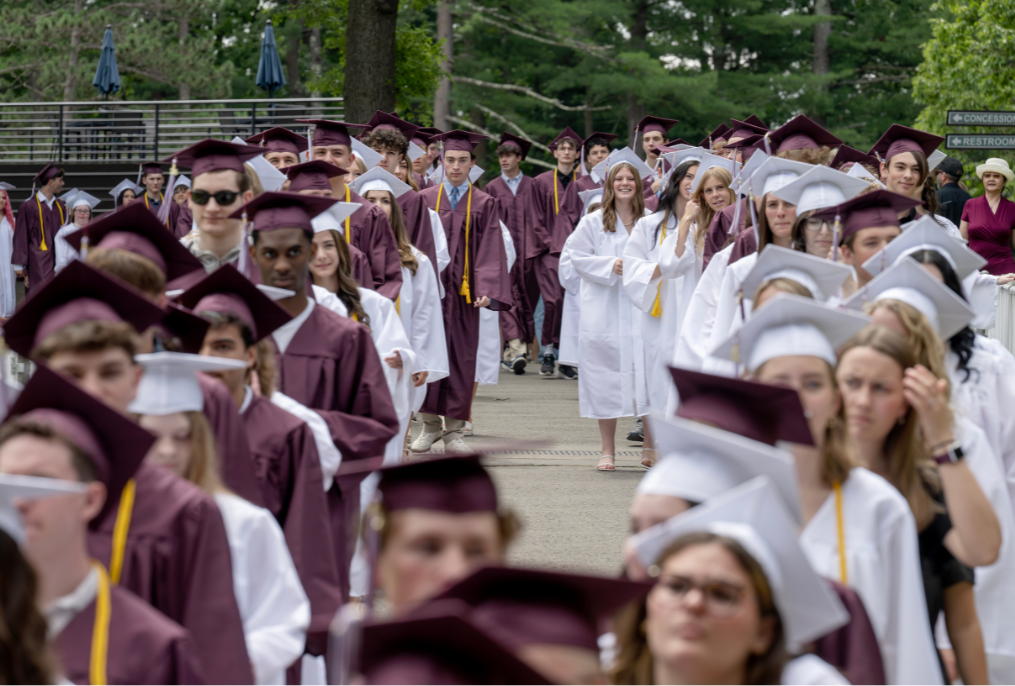 A wide shot of BHBL graduates in maroon and white caps and gowns for graduation.