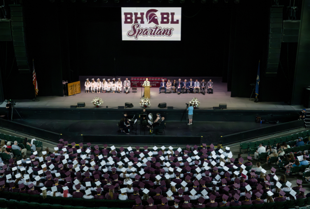 A wide shot from graduation with the superintendent speaking.