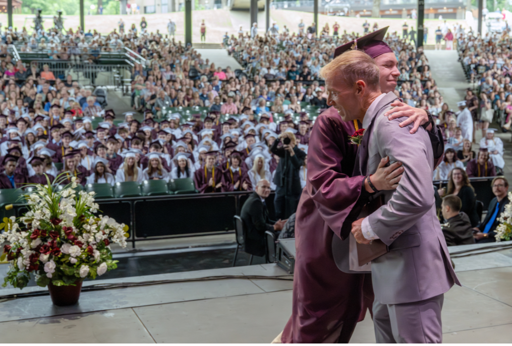 A BHBL graduation hugging the superintendent.