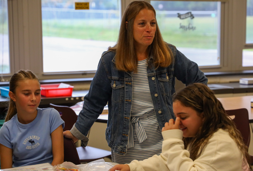 A teacher talking to students at the middle school