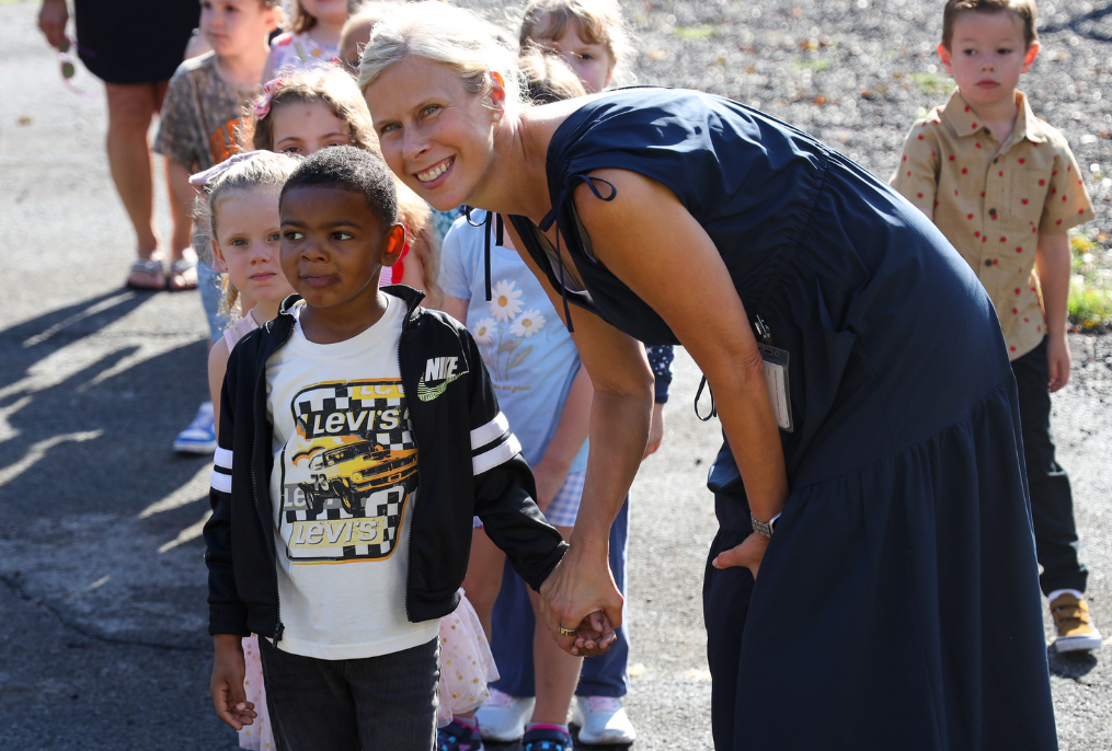 A teacher outside with a student on the first day of school.