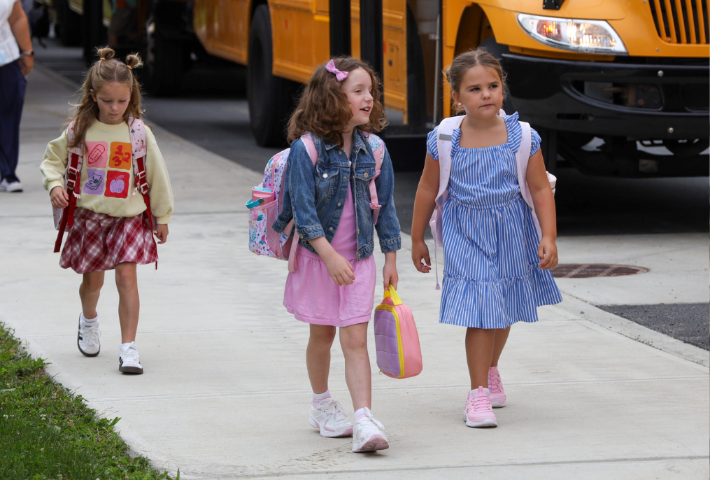Students walking from the bus to school on the first day