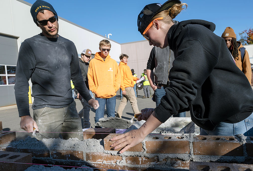 a student laying bricks
